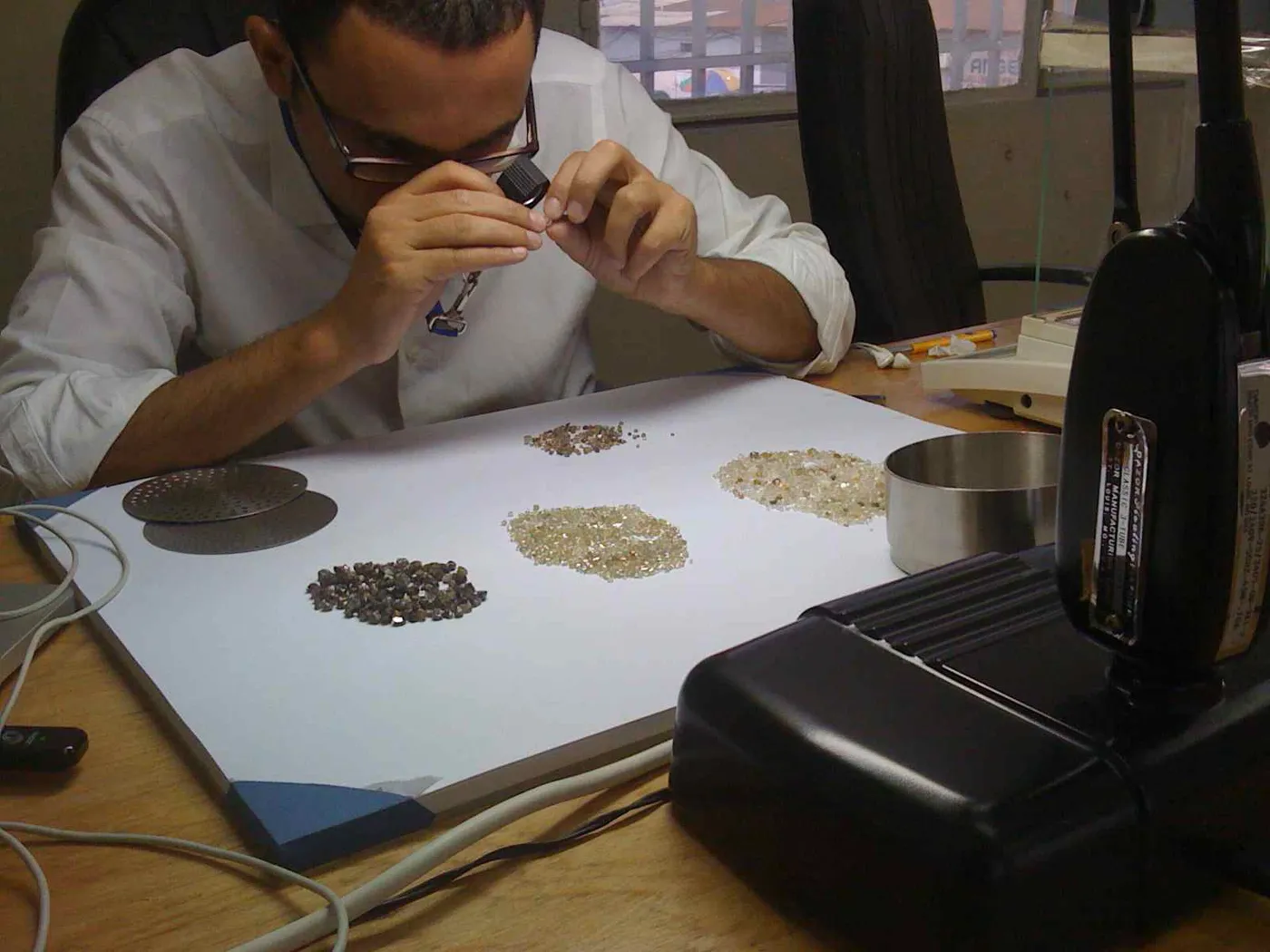 Laurent de Toledo trie des diamants bruts à la loupe
