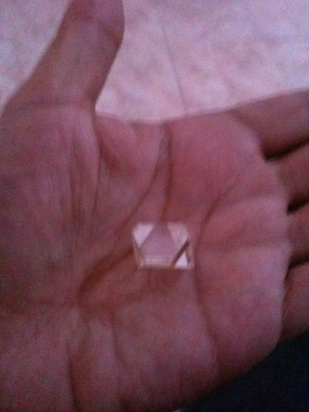 Petit diamant brut octaèdre posé dans la paume de la main