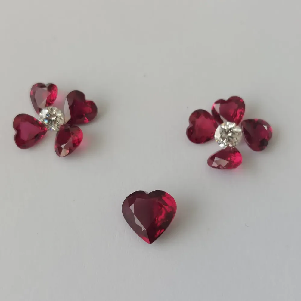 Rubis taille cœur disposés en fleur autour d'un diamant